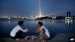 지난 7월 북한 원산 앞 장덕도에서 주민들이 화덕에 해산물을 굽고 있다. 북한은 최근 원산을 세계적인 휴양지로 개발하겠다며 해외 투자설명회를 열기도 했다. (자료사진)