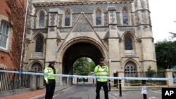 Police stand guard at the Abbey gateway of Forbury Gardens, a day after a multiple stabbing attack in the gardens in Reading, England, Sunday June 21, 2020. British police say they are treating a stabbing rampage in a park that killed three people…