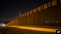 FILE - A portion of the new steel border fence stretches along the U.S.-Mexico border in Sunland Park, New Mexico, March 30, 2017.