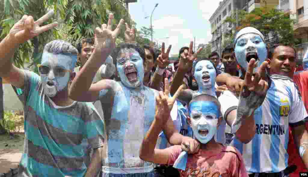 Young boys paint the flag of Argentina on their faces and bodies ahead of the World Cup games, Bangladesh, June 8, 2014. (VOA)