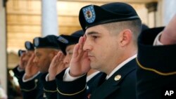 FILE - A group of Army recruiters salute during the playing of the national anthem at the change of command ceremony for the Jackson, Mississippi, Army Recruiting Company of the U.S. Army Recruiting Baton Rouge Battalion, March 12, 2014.