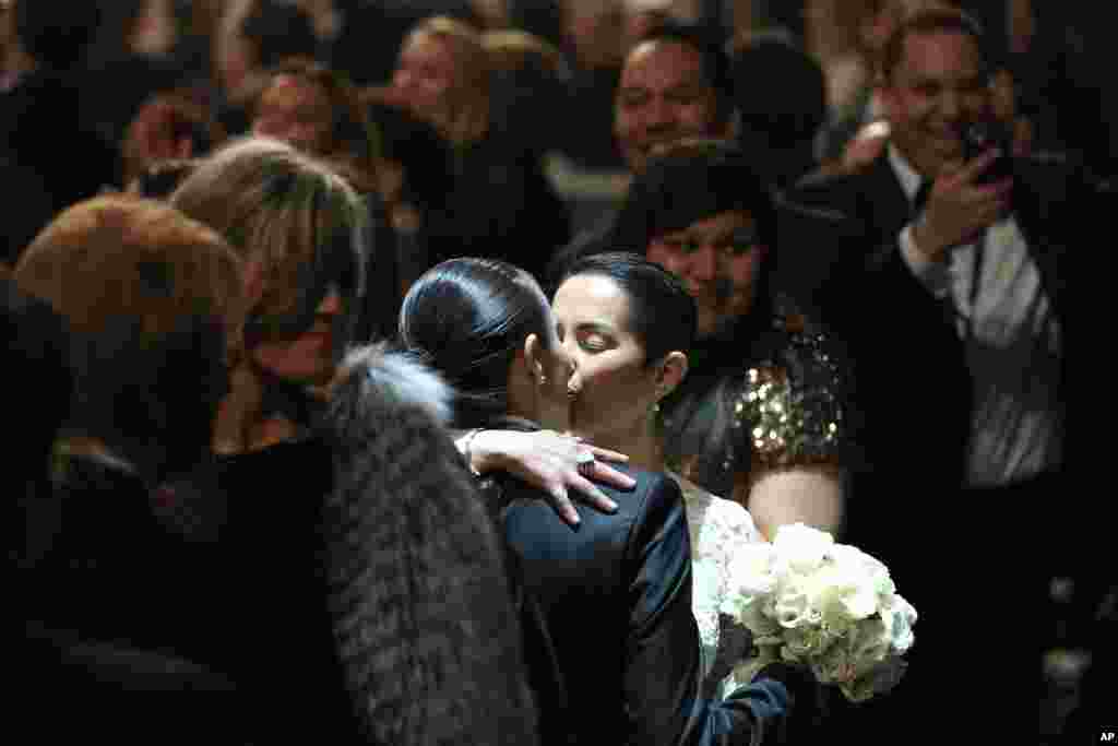 Beberapa pasangan yang berpartisipasi dalam pernikahan sesama jenis yang berlangsung saat pertunjukan lagu "Same Love" dari Macklemore and Ryan Lewis pada Grammy Awards ke-56. (AP/Matt Sayles)