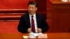 Chinese President Xi Jinping adjusts his jacket during the opening session of the Chinese People's Political Consultative Conference (CPPCC) was held in Beijing, China, March 3, 2017. 