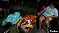 People rest at a makeshift camp outside their apartment building after an earthquake in Yauco, Puerto Rico, Jan. 7, 2020.