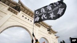 一名在台灣的香港人在台北自由廣場舉旗抗議中共在香港的暴政。（美聯社照片）