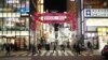 Warga berjalan-jalan di kawasan Shinjuku, Tokyo, Kamis, 7 Januari 2021, setelah PM Jepang Yoshihide Suga mengumumkan keadaan darurat mulai Jumat (8/1), seiring meningkatnya kasus positif Covid-19. (AP Photo/Hiro Komae)