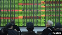 春节后中国股市开市头一天出现了崩溃式下滑。图为浙江省杭州市的股民坐在一交易所的电子屏幕前观看行情。（2020年2月3日）
