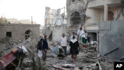 FILE - People inspect the damage of houses destroyed by Saudi-led airstrikes in Sanaa, Yemen, Jun. 9, 2017. 
