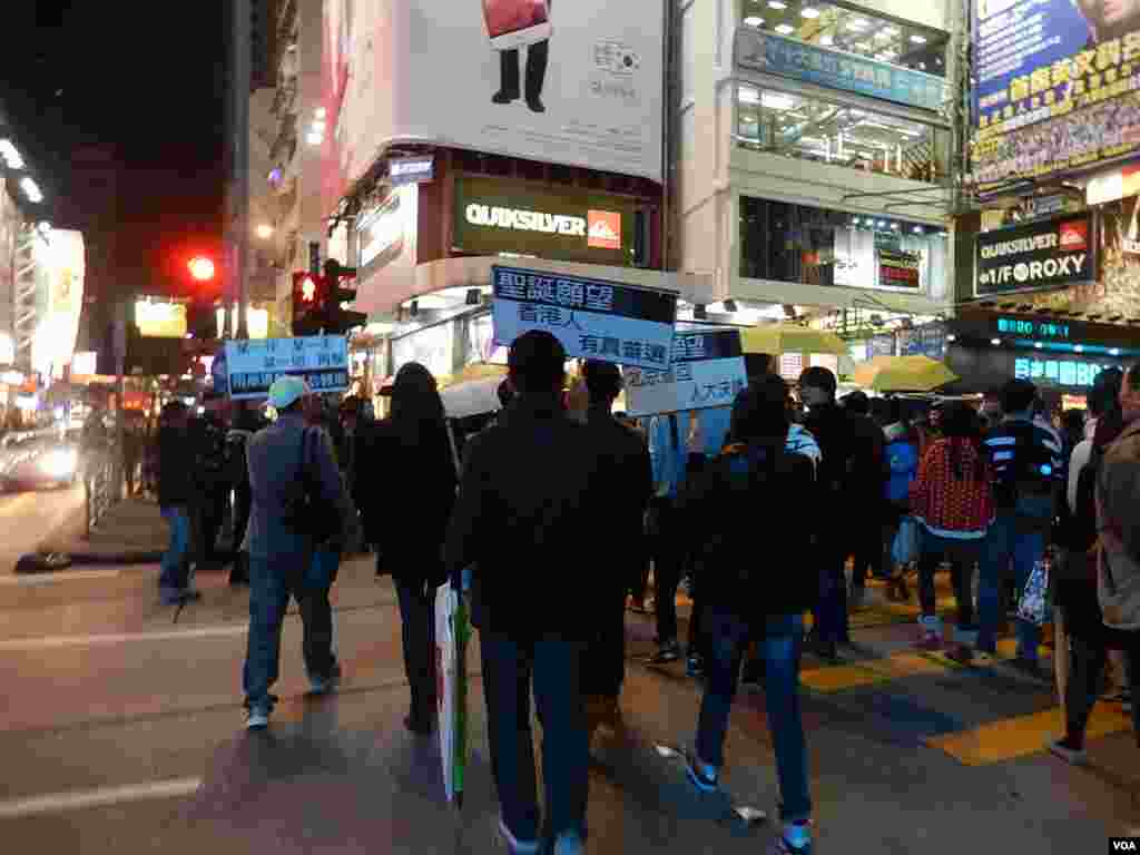 警方向旺角「購物團」人士高舉警告標語,將部份人封鎖在一條馬路上