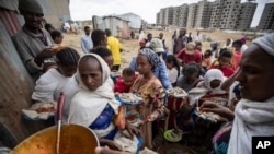 FILE - Displaced Tigrayans queue to receive food donated by local residents at a reception center for the internally displaced in Mekele, in the Tigray region of northern Ethiopia, May 9, 2021.