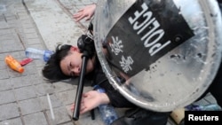 FILE - Police arrest a protester after a Chinese flag was removed from a pole at a rally in support of Xinjiang Uighurs' human rights in Hong Kong, China, Dec. 22, 2019.