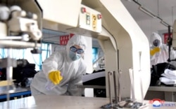 FILE - Volunteers carry out disinfection work during an anti-virus campaign in Pyongyang, North Korea, in this image released by North Korea's Korean Central News Agency (KCNA), March 4, 2020.
