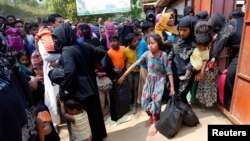 FILE - Rohingya refugees collect aid supplies including food and medicine, sent from Malaysia, at Kutupalang Unregistered Refugee Camp in Cox’s Bazar, Bangladesh, Feb. 15, 2017.