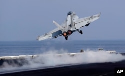 Sebuah jet tempur Angkatan Laut A.S. lepas landas dari dek A.S. Kapal induk Dwight D. Eisenhower. (Foto: AP)