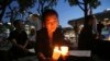 FILE - A woman lights candles during a service for peace on the Korean Peninsula near the U.S. Embassy in Seoul, South Korea, Aug. 31, 2017. 