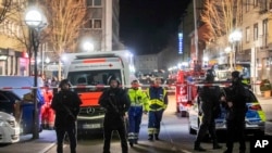 Police guard the scenery in front of a restaurant in central Hanau, Germany Thursday, Feb. 20, 2020. German police say several people were shot to death in the city of Hanau on Wednesday evening. (AP Photo/Michael Probst)