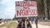 FILE - A man holds a placard reading, "Congo is not the property of Nguesso," during a demonstration against President Denis Sassou Nguesso in Brazzaville, Republic of Congo, Sept. 27, 2015.