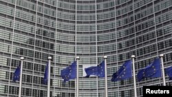 European Union flags are seen outside the European Commission headquarters in Brussels in this October 27, 2010, file photo.