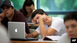 FILE - University of Miami student Gabriel Dias studies the daily lesson plan on his computer during a Spanish class in Coral Gables, Florida, Sept. 9, 2013.