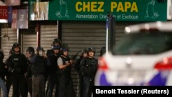 Polisi Perancis mengamankan wilayah dalam adu tembak di Saint-Denis, dekat Paris (18/11), dalam operasi berburu buronan. (Reuters/Benoit Tessier)