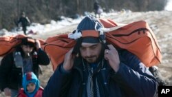 Migran membawa barang-barang mereka dari perbatasan Makedonia menuju Serbia, dekat desa Miratovac, Serbia, 19 Januari 2016.