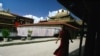 FILE - A Tibetan monk walks along the halls of the Jokhang Buddhist temple in Lhasa, Tibet.