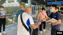 元朗區議員林進（右）及多名天水連線成員8月11日早上7時開始在天水圍西鐵站，免費向市民派發超過1千份蘋果日報。(美國之音湯惠芸)