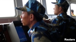 越南巡逻艇上的人员在南中国海有争议水域观察附近的中国军舰。（资料照）