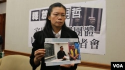 李明哲的妻子李淨瑜向媒體展示李明哲以往活動的照片(美國之音楊明拍攝 資料照片)