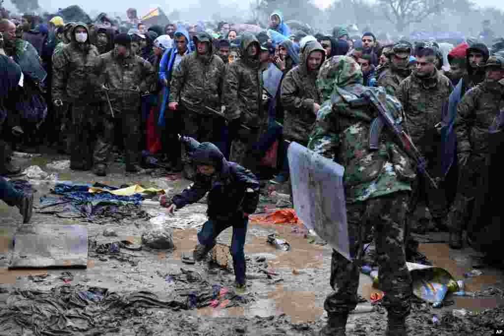 A boy passes from the northern Greek village of Idomeni to southern Macedonia as other refugees and migrants wait, Sept. 10, 2015. Thousands of people, including many families with young children, braved torrential downpours to cross Greece’s northern border with Macedonia, after Greek authorities managed to register about 17,000 people on the island of Lesbos, allowing them to continue their journey north into Europe.