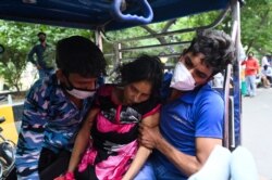A patient collapses as she is rushed on a cycle rickshaw outside a Gurudwara (Sikh Temple), which provides free oxygen to patients amid COVID-19 surge in Ghaziabad, India.