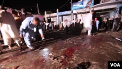 Petugas keamanan Pakistan mengumpulkan bukti-bukti di lokasi ledakan bom di Risalpur, dekat Peshawar (25/8). Ledakan bom sepeda ini menewaskan 11 orang dan merusak beberapa toko dan hotel di dekatnya.