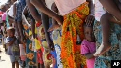 Perempuan dan anak-anak antri untuk vaksinasi kolera di kamp penampungan penyintas topan Idai di Beira, Mozambik, Rabu, 3 April 2019. (Foto: dok).