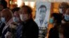 People wearing masks, attend a vigil for Chinese doctor Li Wenliang, in Hong Kong, Friday, Feb. 7, 2020. The death of a young doctor who was reprimanded for warning about China's new virus triggered an outpouring Friday of praise for him and fury…
