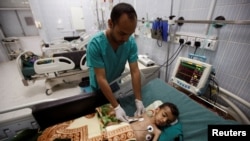 FILE - A nurse checks a boy at a hospital intensive care unit in Sanaa, Yemen, Sept. 27, 2016.