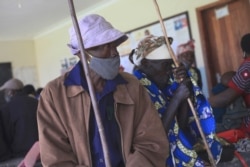 FILE - A couple wait for the COVID-19 vaccine at the Butanda Health Centre III in western Uganda, April 27, 2021.