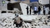 Anggota kelompok Pertahanan Sipil Suriah, White Helmets, memerika kerusakan bangunan akibat serangan udara di daerah Bustan al-Qasr di Aleppo, Suriah (25/9). 