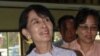 Burma's opposition leader Aung San Suu Kyi (C) waves to the crowd as she leaves National League for Democracy (NLD) headquarters after addressing journalists and supporters in Rangoon on April 2, 2012.