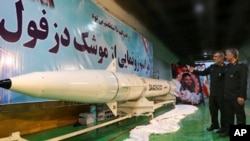 Kepala divisi kedirgantaraan Garda Revolusi Iran, Amir Ali Hajizadeh, kiri, menjelaskan rudan balistik darat ke udara, Dezful, kepada Panglima Garda Revolusi, Mohammad Ali Jafari, dalam sebuah upacara inagurasi di lokasi rahasia (foto: Sepahnews via AP)