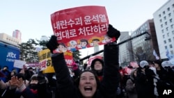 南韓首爾國會外頭，集會民眾聽到南韓投票彈劾總統尹錫悅的消息後慶祝。 (美聯社：2024年12月14日)