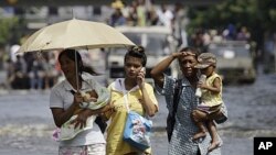 ဘန်ကောက်မြို့က ရေလျှံနေတဲ့လမ်းမတွေပေါ်မှာ သွားလာနေကြသူတချို့ (နိုဝင်ဘာလ ၆၊ ၂၀၁၁)