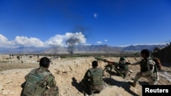 FILE - Afghan security forces take position during a gun battle between Taliban and Afghan security forces in Laghman province, Afghanistan, March 1, 2017. 